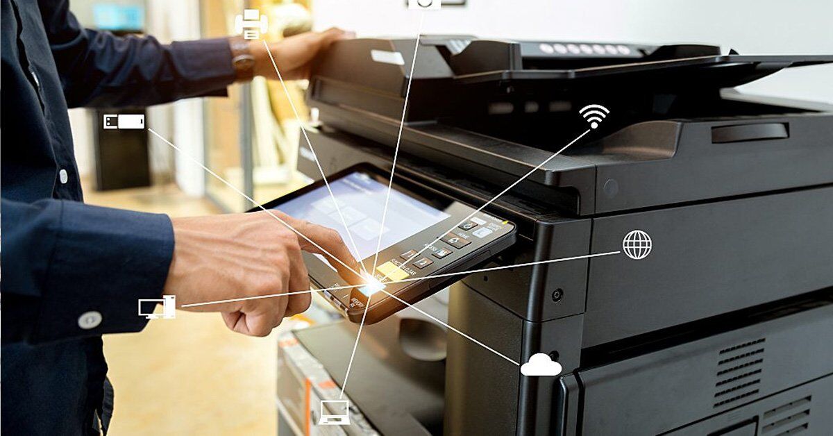 A person's hand interacts with a multifunction printer, with icons representing various digital connections and devices