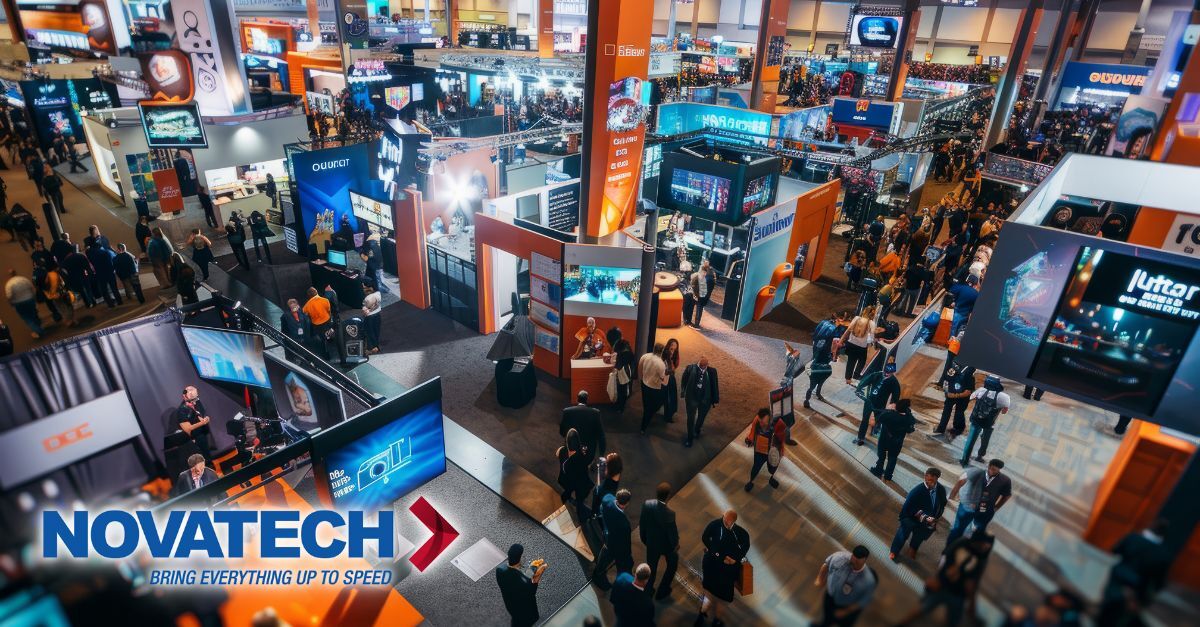 An aerial view captures a bustling trade show floor with numerous attendees browsing various exhibition booths.