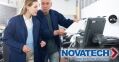 Two people in blue lab coats examine documents near a printer, with the Novatech logo overlaid.
