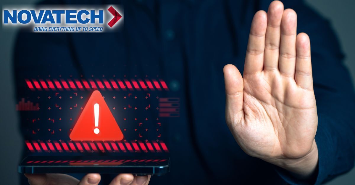 A person holds up their hand in a stop gesture in front of a digital display showing a warning sign and the Novatech