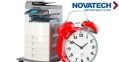 A red alarm clock sits next to a printer, with the 