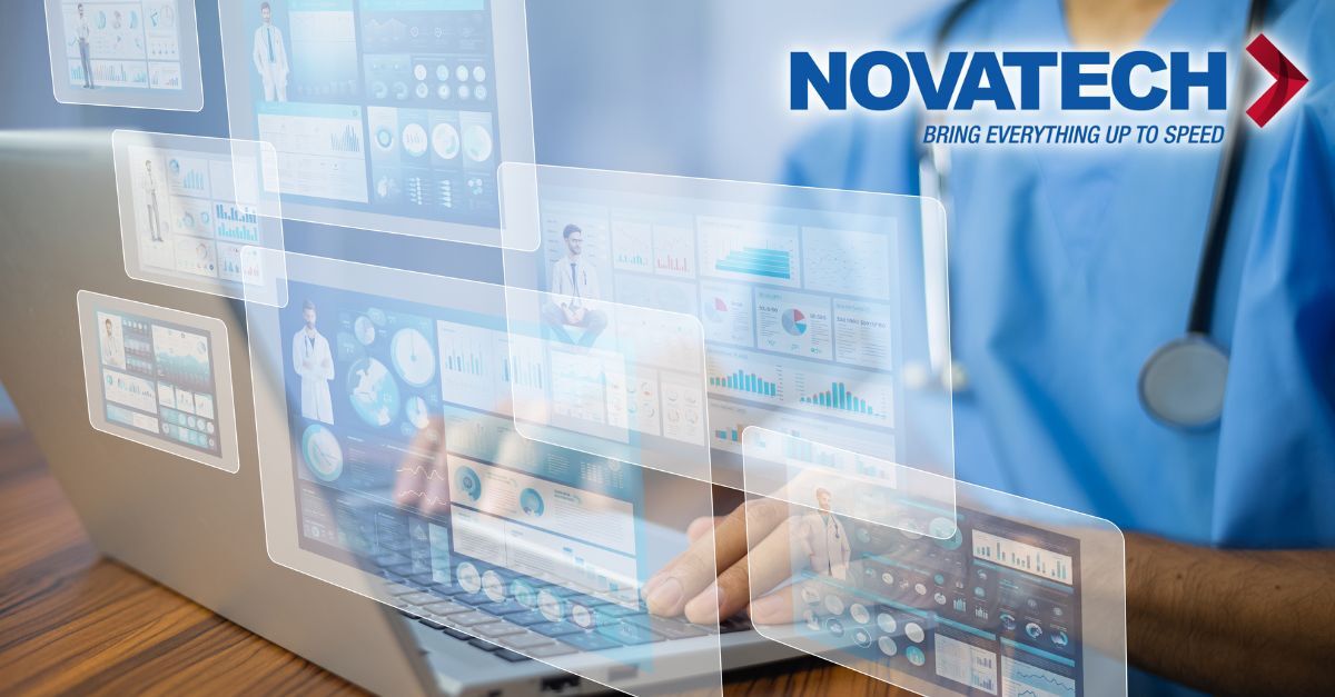 A healthcare professional in blue scrubs uses a laptop displaying multiple holographic medical data interfaces.