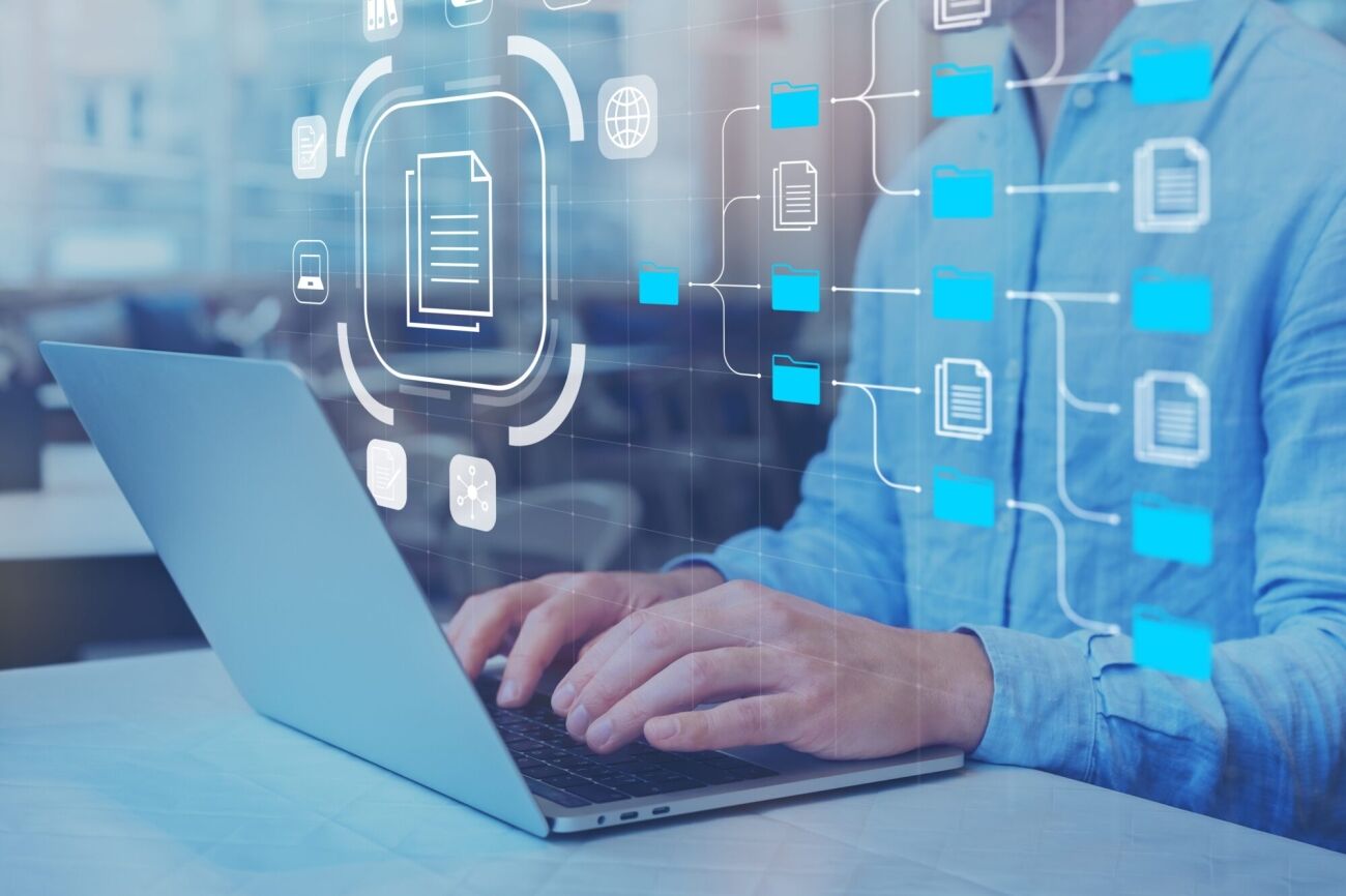 A person's hands are typing on a laptop, with a digital interface overlay showing a file management system.