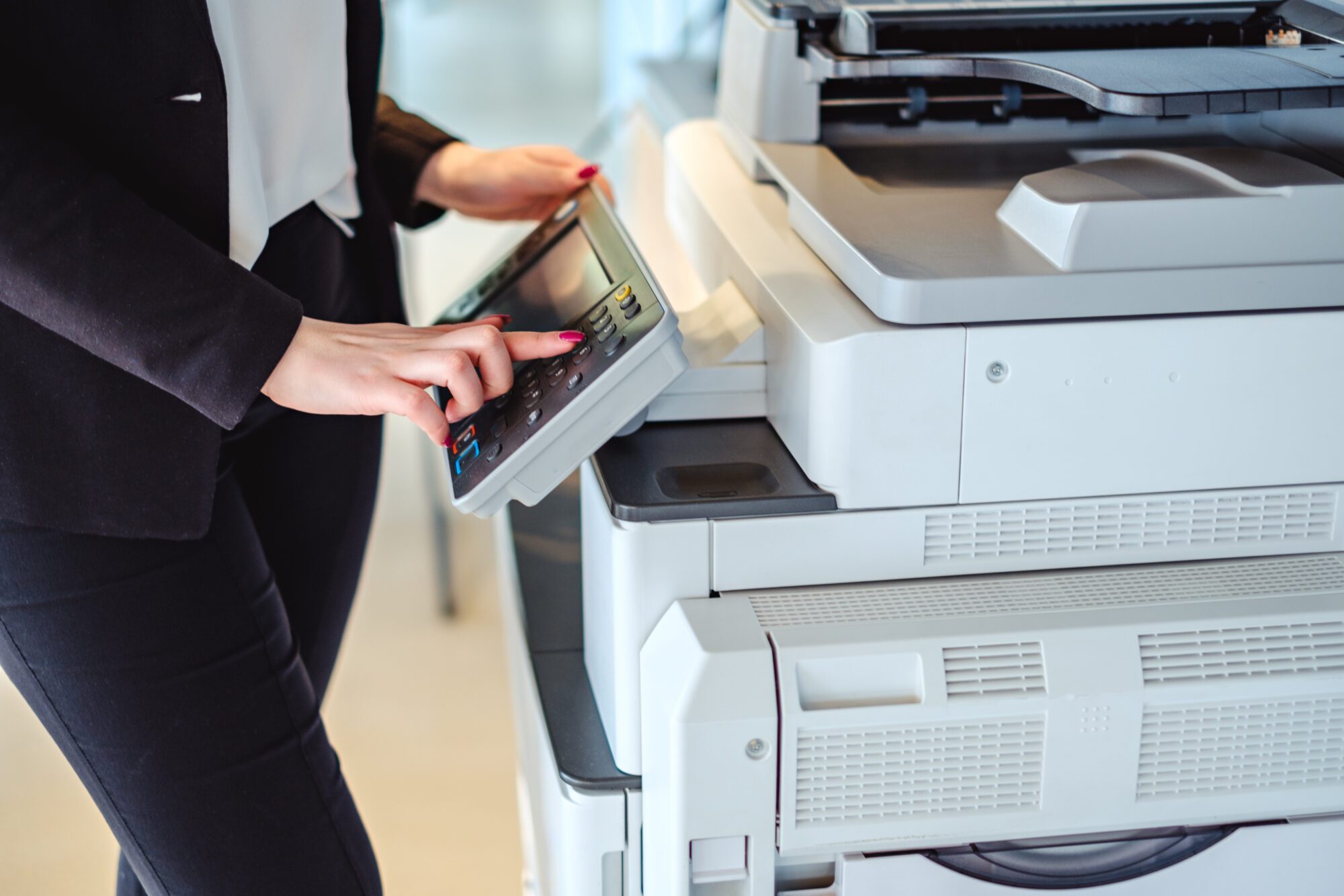 A person in a suit is operating a copier machine.
