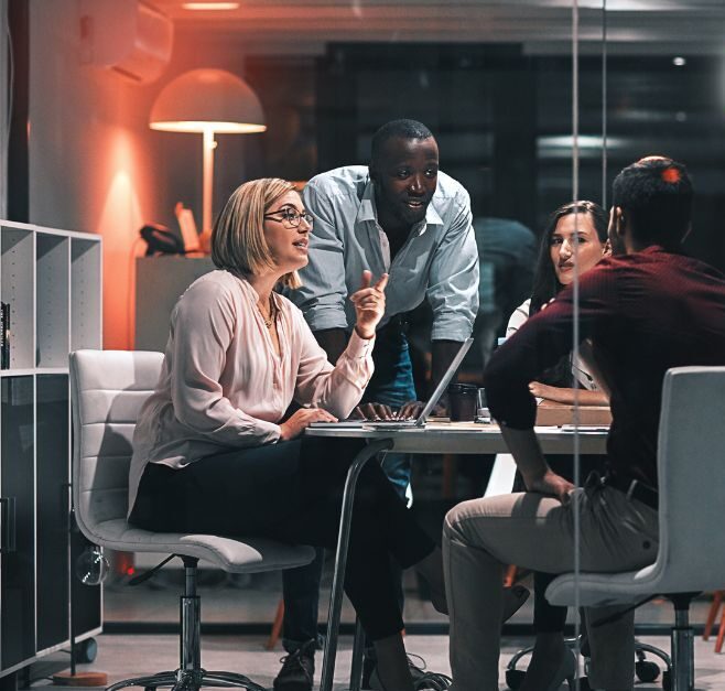 A diverse group of professionals collaborates around a table in a modern office setting, with the 